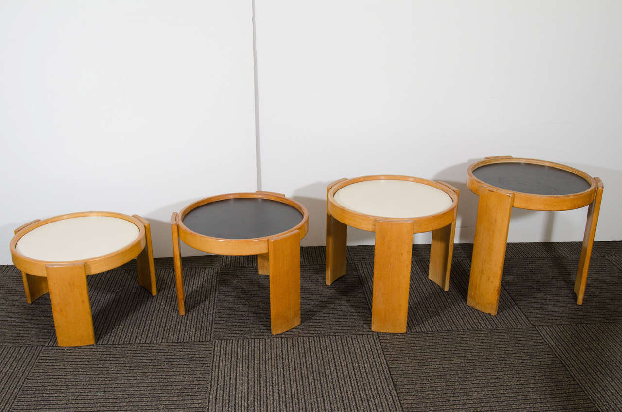 A vintage set of four stacking tables in beechwood with reversible black and white laminate tops by Gianfranco Frattini for Cassina. Good vintage condition with age appropriate wear. Some scuffs to the wood.