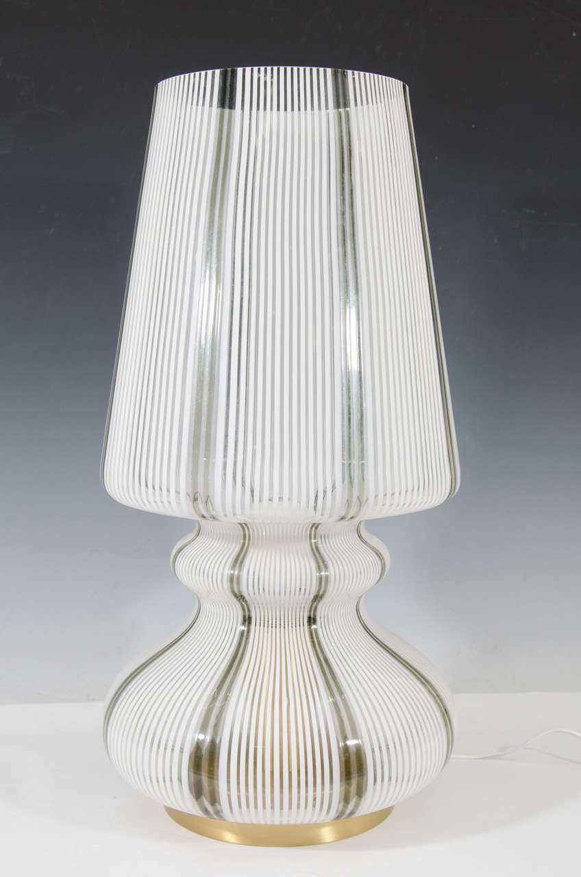 A vintage pair of white and dark greenish gray striped Murano table lamps with glass shades and brass base.  These lamps take one Edison base bulb.  Switch is located on the electrical cord.

Good vintage condition with some wear to the base.