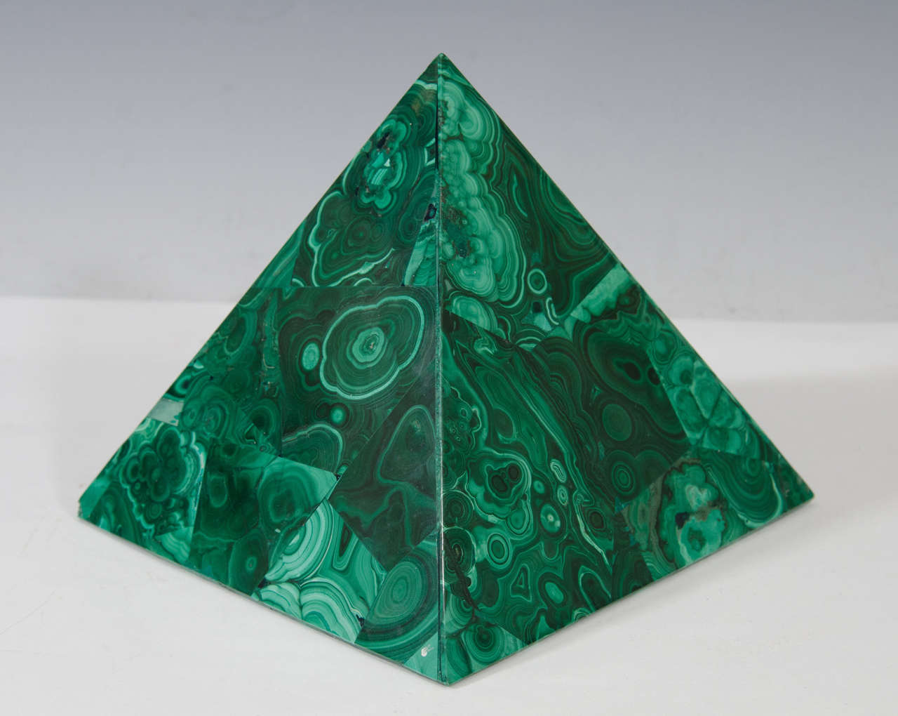 A malachite decorative pyramid with green swirl detailing. 

Good condition with age appropriate wear. A chip to one corner.