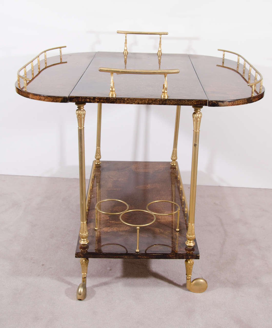 Aldo Tura Bar cart in brass and Deep Marbelized Brown Lacquered Goatskin with Galleried top and three wine or bottle holders on the Bottom Tier.

Dimensions closed: 
H 30
