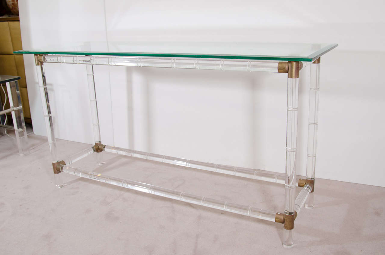 A vintage Lucite console table by Charles Hollis Jones with glass top and brass corner accents.

Good vintage condition with age appropriate wear.  Some faint scratches to the glass.