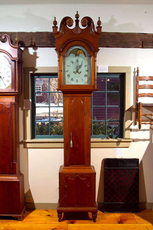 Lebanon County, Pennsylvania Tall case clock, circa 1810.<br />
An eight day brass works tall case clock with Painted Dial <br />
signed Gustavus Stoy. In a Walnut case with a Swans Neck <br />
pediment and carved sunflower rosettes.<br />
In