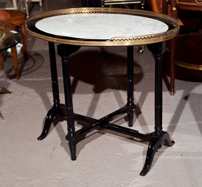 Hollywood Regency style ebonized tilt-top table with marble top, bronze pierced gallery. Table folds up to sit into corner or lays to serve dinner or play cards on.