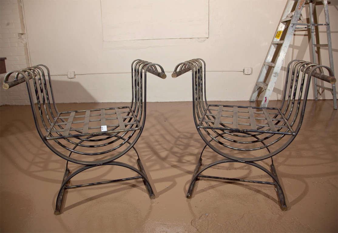 Pair of 20th century garden steel benches, raised and scrolled arms and domed bases.