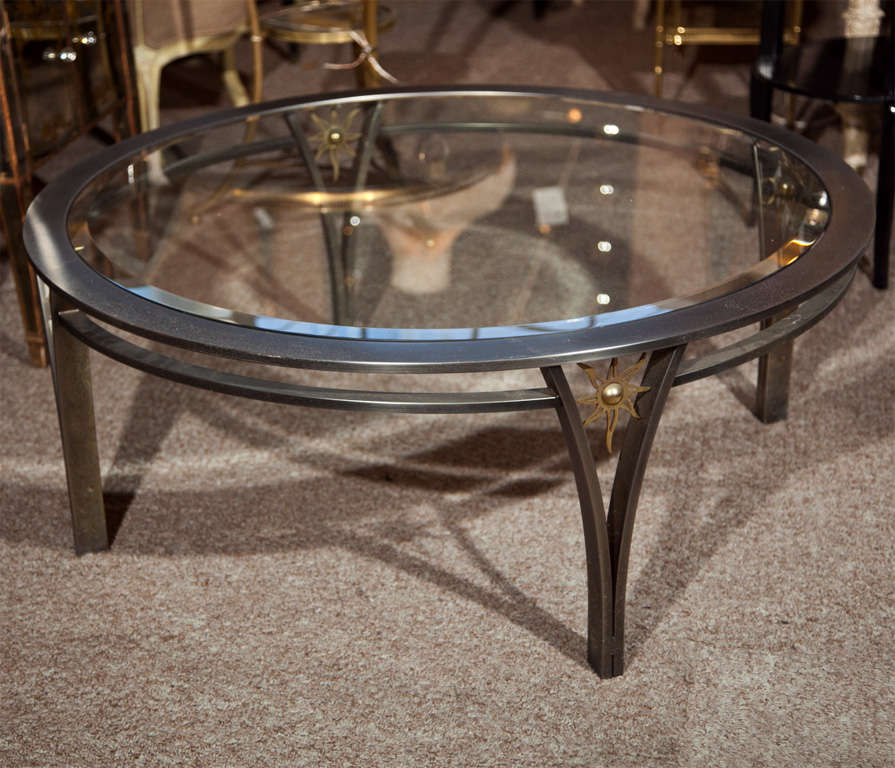 Vintage French coffee table, round glass top supported by steel and brass base. Attributed to Maison Jansen.