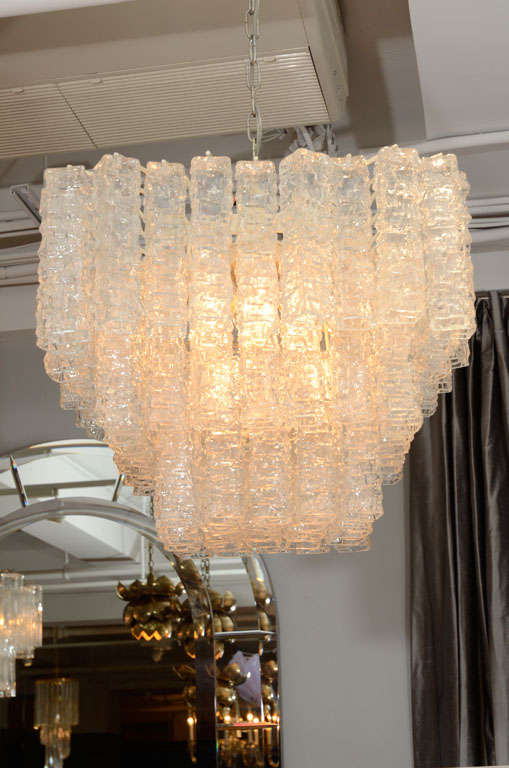 A dazzling square shaped Venini chandelier composed of molded, clear glass tubes hanging on a metal frame.