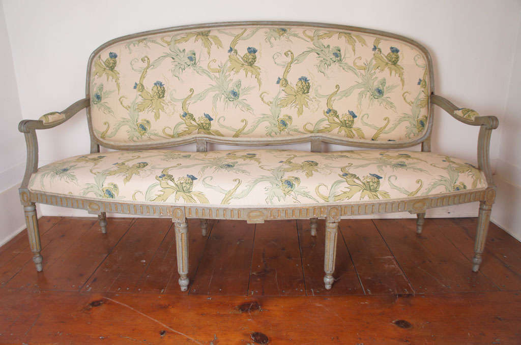 Fine early 19th century Swedish grey-painted Settee, shaped and carved back over an upholstered seat; carved downswept arms. Seat with a fluted apron raised on eight tapering legs ending in ball feet.