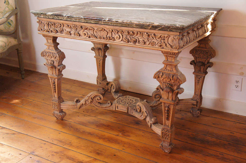 Fine moulded marble top over a frieze with acanthus and floral designs centered with a shell. On four carved and tapering legs united by a carved stretcher.
