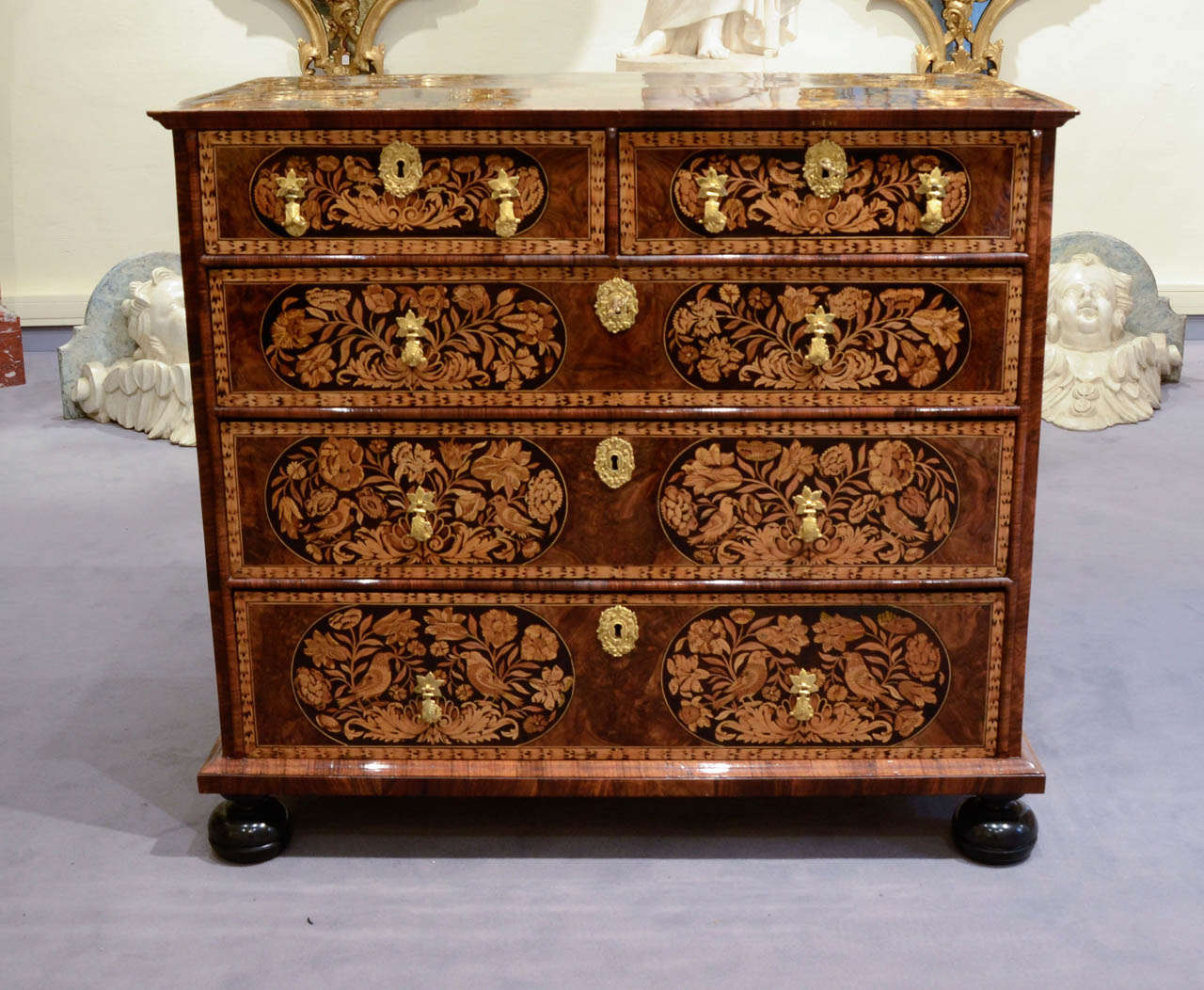 Rectangular shape. With five drawers on four rows. Flowery and birds decor on a black wood background and walnut scrolls. Woods employed for the marquetry are: sycamore, hornbeam wood, Barberry, maple, birchwood and walnut. The opening handles and