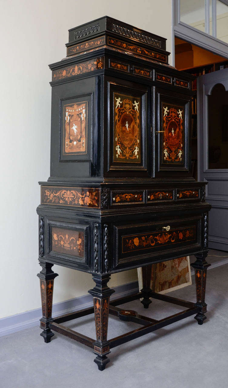 Two front doors, three drawers on the top part and two large drawers on the bottom, twelve drawers inside. Indigenous and exotic wood, ivory and mother-of-pearl marquetry. Straight feet with crossbars. Anthropomorphic, zoomorphic and vegetal decor