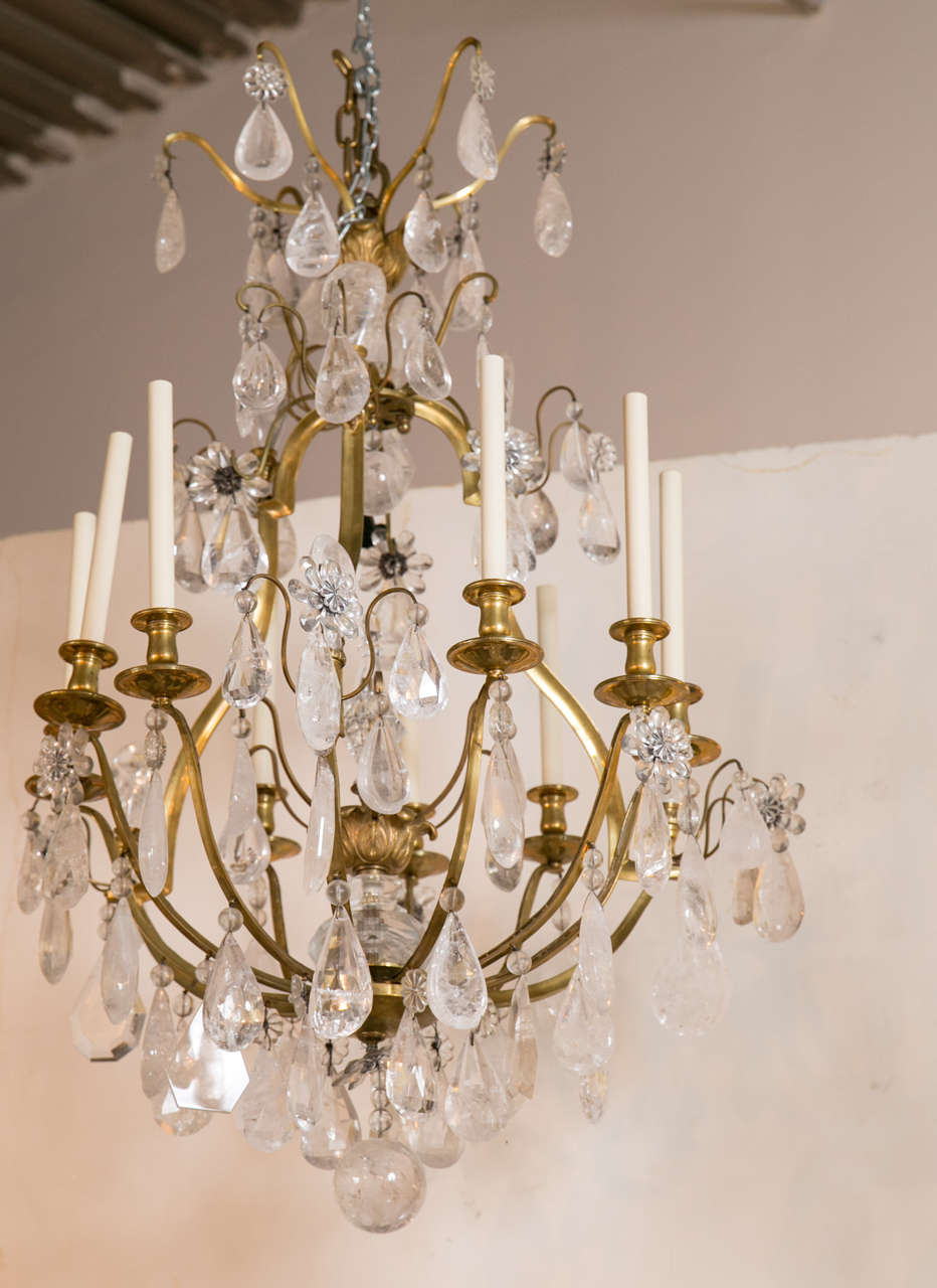 A fabulous nine-light grand Bagues chandelier of brass and bronze, adorned with original faceted rock crystals.