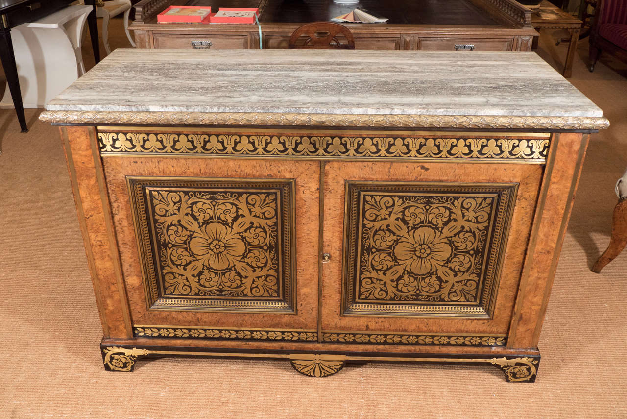 Attributed to George Bullock. The rectangular ormolu-mounted grey travertine marble top, above two doors with 'premiere partie' Boulle-work panelled doors, above a shaped brass-inlaid ebony veneered apron and feet. The panelled sides with