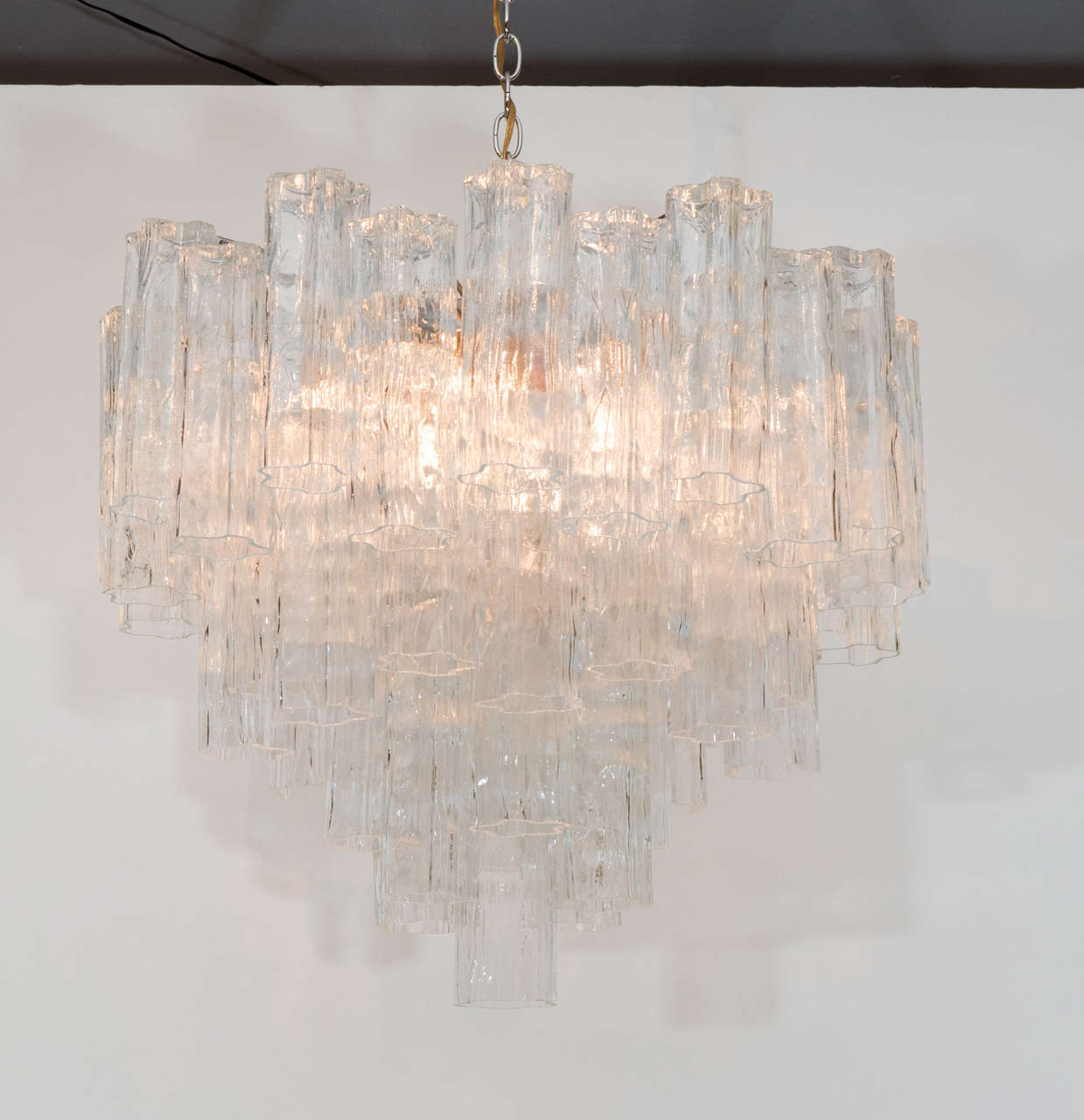 Grand and showy chandelier. The piece has a beautiful form with multiple tiers of Murano tronchi crystals suspended from a chrome armature. Please contact for location.