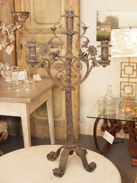Pair of highly decorative forged iron Italian candelabra, embellished with, among other things, leaves, flowers, spirals and crosses.