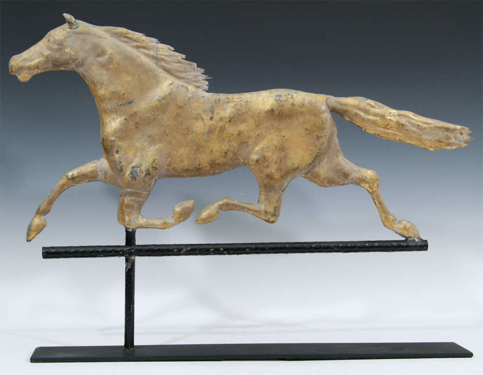 A late 19th Century weathervane mounted on a wrought iron stand depicts a gilded copper horse at full gallop. A wonderful Early American style decorative piece for a country setting.