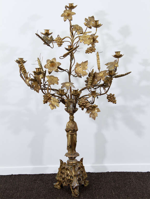 Pair of 20th Century Neo-Classical Toles. Figural base with a bouquet of wheat, lilies, oaks leaves and grapes blooming out of the top. Each Candelabra holds 11 candles.<br />
<br />
Reduced From: $8,500