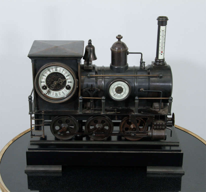 A steel scale model of an 1880s locomotive inset with a working key wound clock, a barometer and a thermometer captures the spirit of the 1880s American railroads.  The locomotive has all its bells and whistles including its original set of keys for