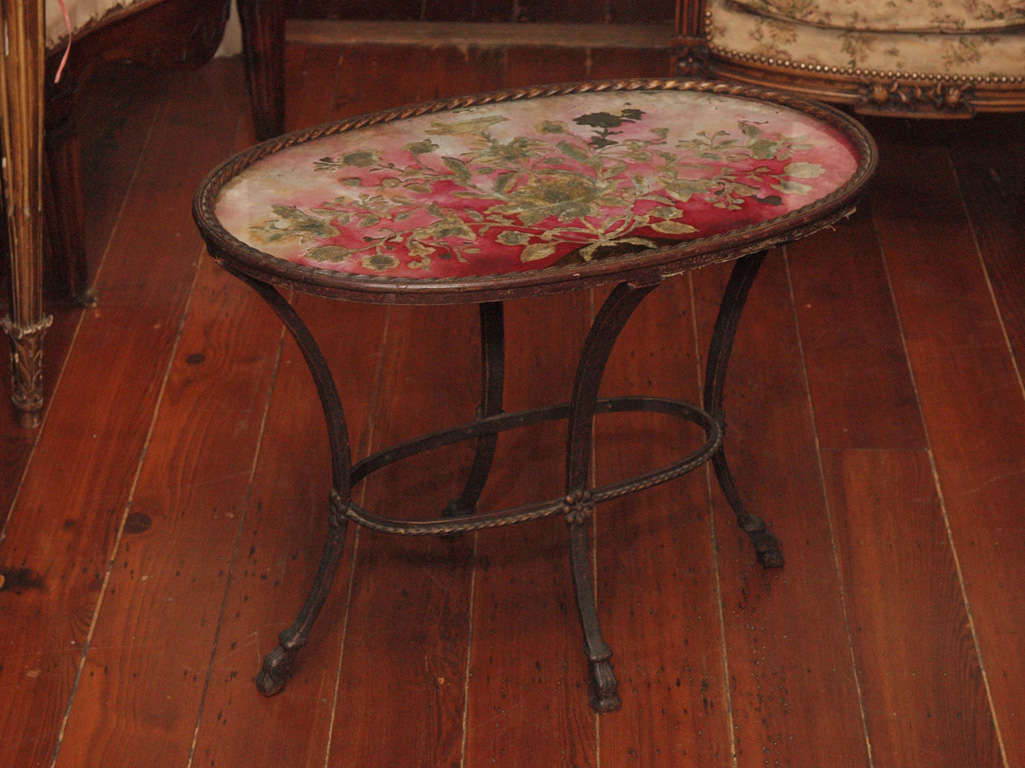 A Small, Oval Side Table With A Textile-under-glass Top