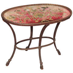 A Small, Oval Side Table With A Textile-under-glass Top