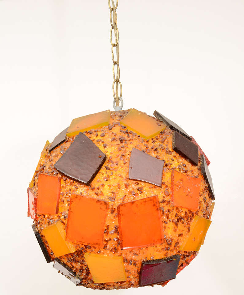 Bold resin globe light fixture nicely  accented with squarish resin appliqués.