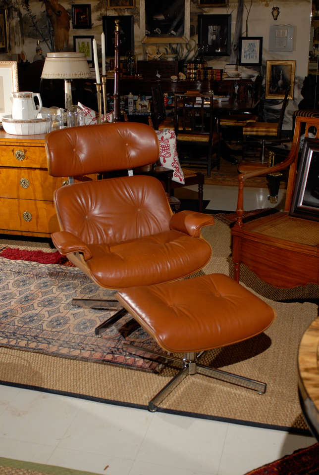 Mid Century Italian pair of Eames style lounge chairs and ottomans with leather upholstery.