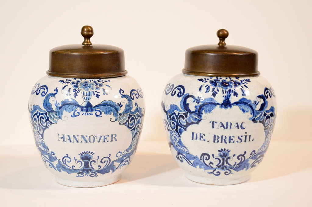 A pair of small Dutch Delft Blue and White tobacco jars, labeled 
