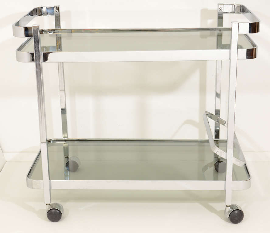 A vintage chrome frame two tier serving cart in the style of Milo Baughman with smokey glass surfaces and bottle rack.