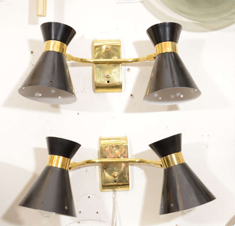 A pair of vintage wall lamps with brass mounts and two pivoting lights with black enameled metal shades with star perforations around the edge.

Available Separately ($2200 each)