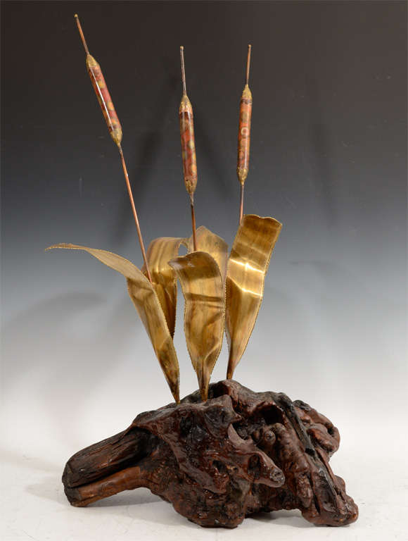 A whimsical sculpture of brass cattails and leaves mounted on a root base. The piece is similar to works produced by Curtis Jere.

Reduced from $650.00