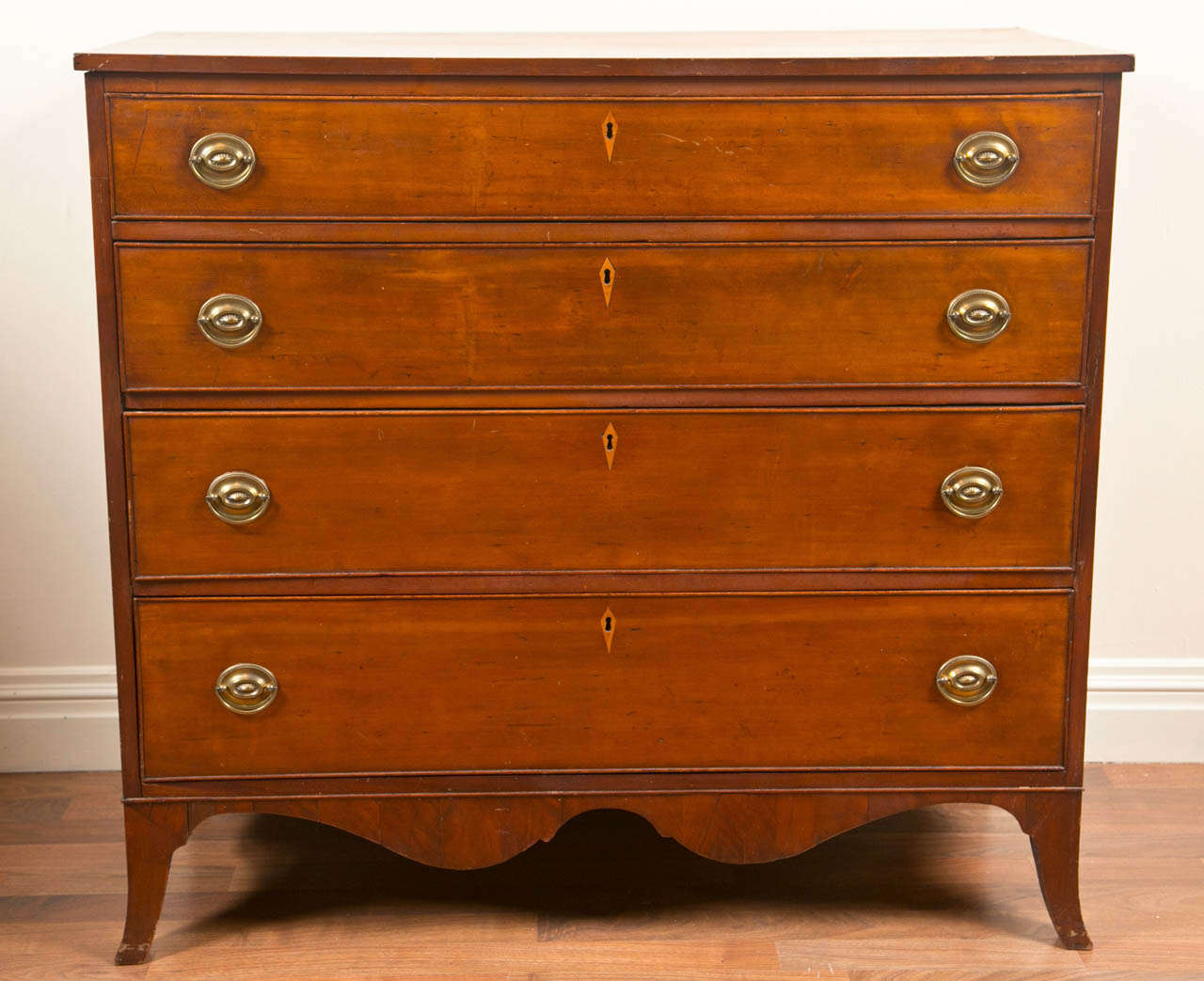 A good American Cherry wood Federal period chest of drawers on a shaped apron and splayed feet, circa 1830.