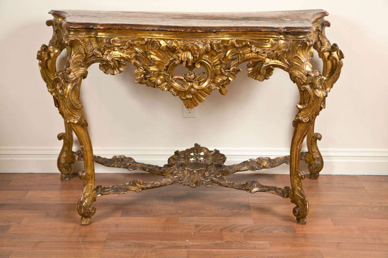 A good Italian carved and gilt wood rococo console with its original faux marble top , Naples circa 1750.