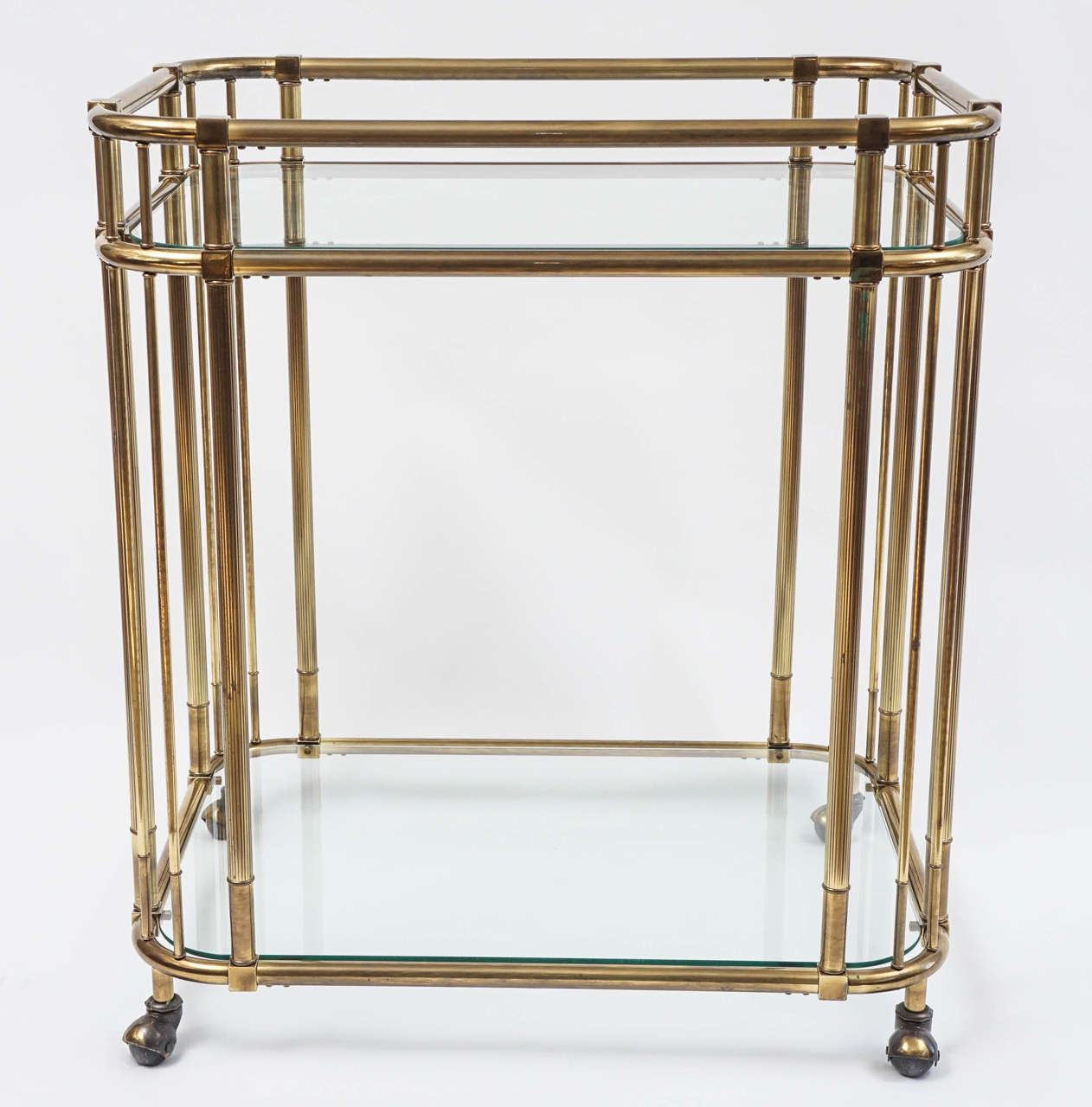 Classy cart with casters and curvy corners. Two sturdy glass shelves make the cart as practical as it is stylish. I have opted not to polished the brass as the patina reflects the elegance earned by age and use. Great in any setting!