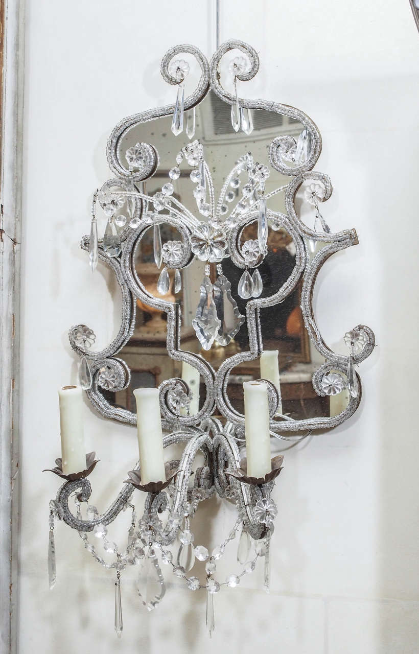 Pair of exquisite Venetian sconces formed with cartouche shaped mirrored back, outlined with glass beads, three iron arms lined with glass beads and linked with crystal swags and drops, electrified.