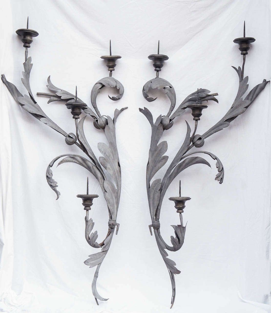 This large pair of four light pricket sconces created from wrought Iron and forged iron with wood sections for the candles to rest on are most likely Italian but could be French as well. The metal work hand forged looks very similar in both