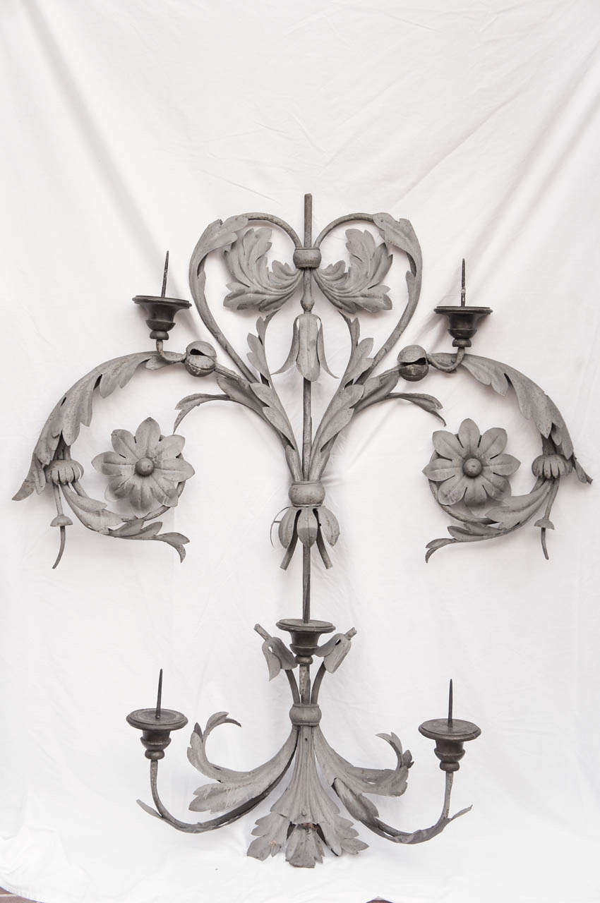 This item is either French or Italian but is hard to tell as metal work in both countries by hand show similar forms and workmanship. This large pricket sconce is made by a combination of forged iron and hand wrought  iron leaves. The pricket points