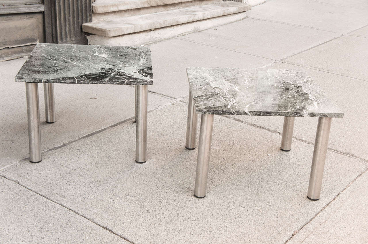 These vintage marble topped coffee tables resting on stainless steel legs are simple and elegant designed to set side by side in front of a sofa. The marble shows a nice selection in veining creating a dramatic focal point visually. While the legs