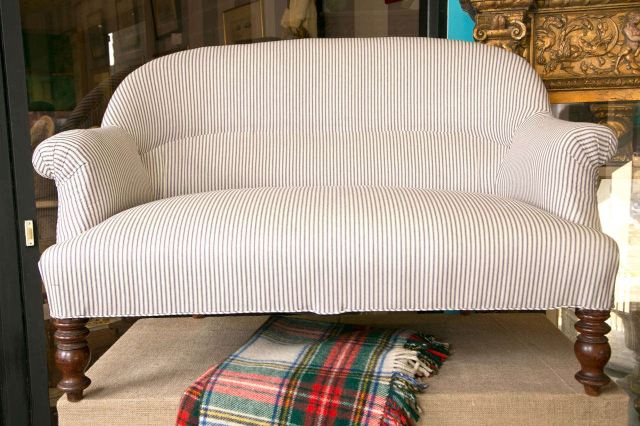 Newly upholstered in ticking stripe This is a great size and comfortable as well.