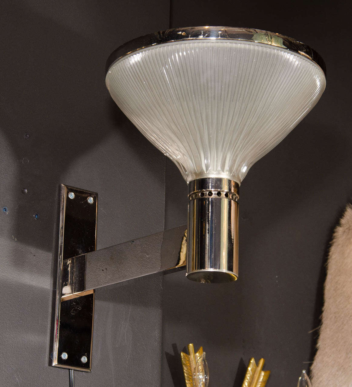 Pair of Mid-Century Modern sconces with uplight domes. The sconces have an Art Deco and Machine Age inspired design. They feature bold polished chrome frames with extended arm design and fluted opaline glass domes with chrome banded detailed tops.