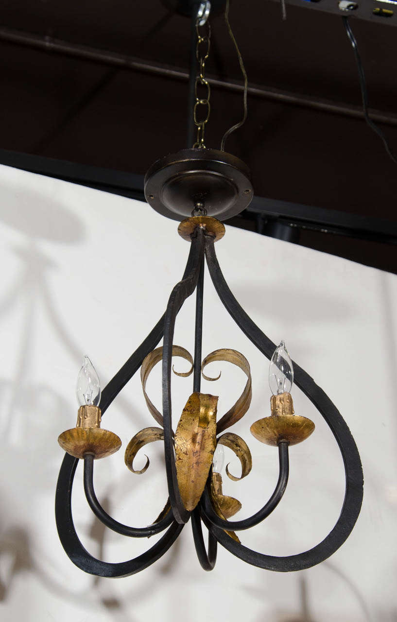 Elegant lantern style pendant light with stylized fig form in black painted wrought iron. The light fixture has fleur de lis center details in antique gold leaf over metal. The fixture is fitted with three lights.  Wonderful scale allows for the
