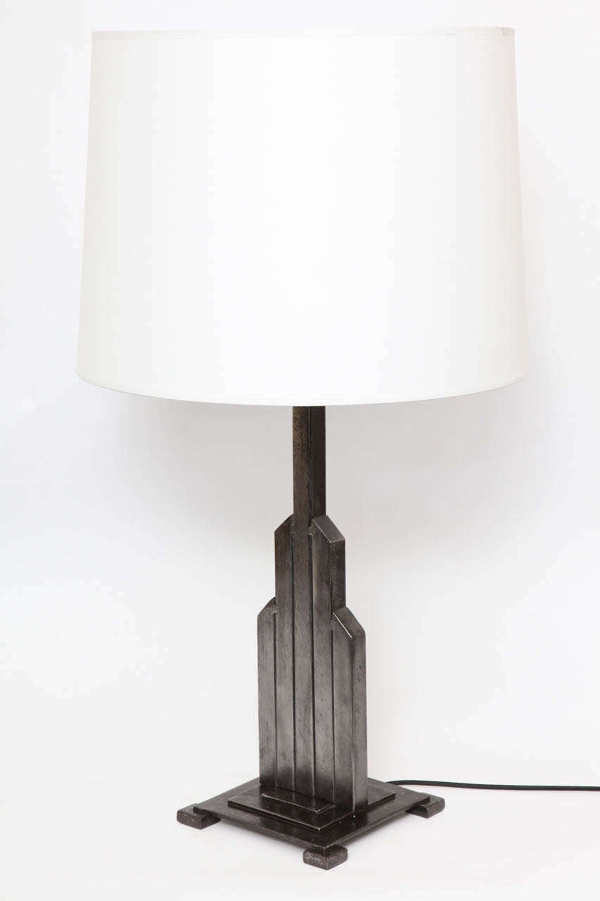 A pair of American modernist table lamps by Jules Bouy, produced, circa 1920s, the architectural skyscraper forms crafted of patinated steel.
