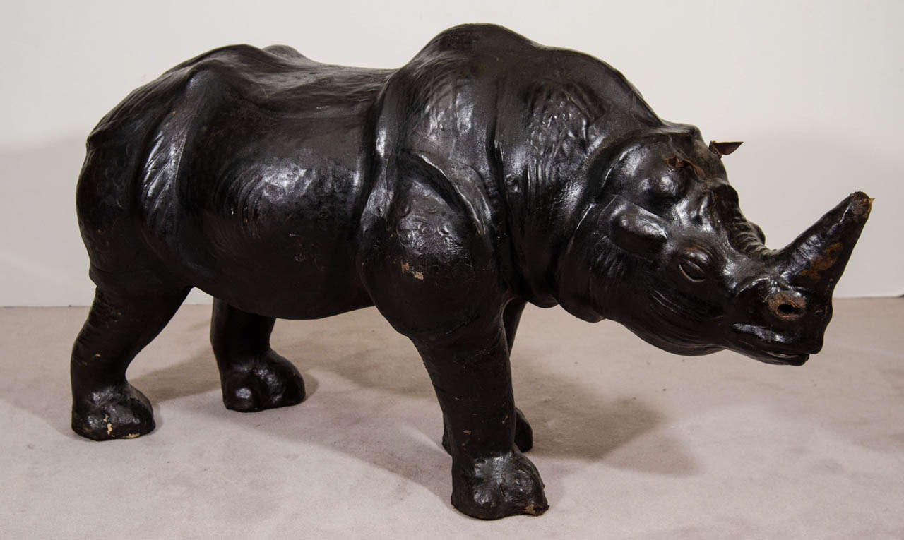 A large 20th Century black leather sculptural Rhinoceros foot stool with plastic eyes.

The Rhino is in good vintage condition with some wear and scratches to the leather.  There are cracks to the eyes.