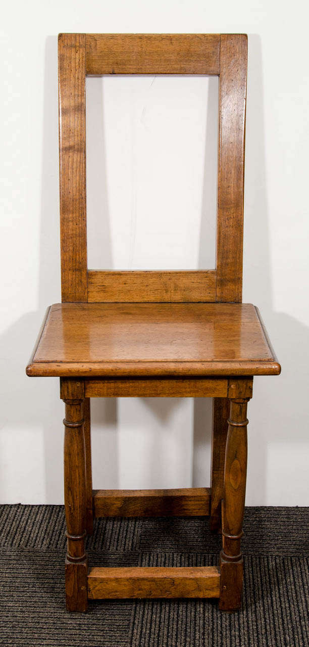 An antique set of four Italian carved wood dining chairs with rectangular backs and square bases. Good condition with age appropriate wear.  Some nicks and scratches to the wood.