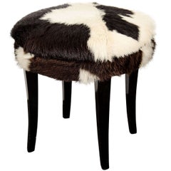 A Mid Century Stool with Cow Hide Upholstery and Ebonized Legs