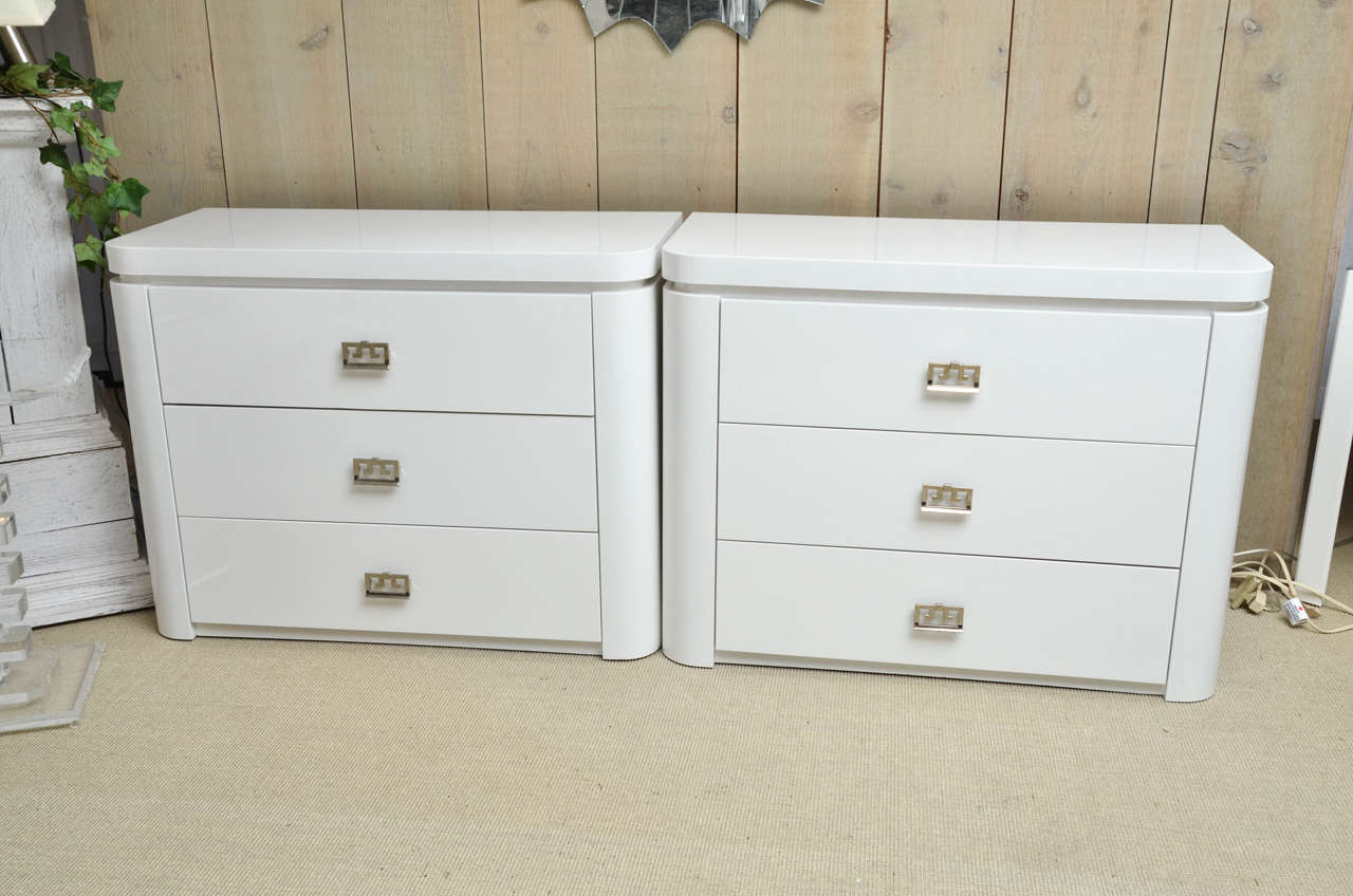 Pair of vintage white lacquer three-drawer commodes with silvered metal drawer pulls.