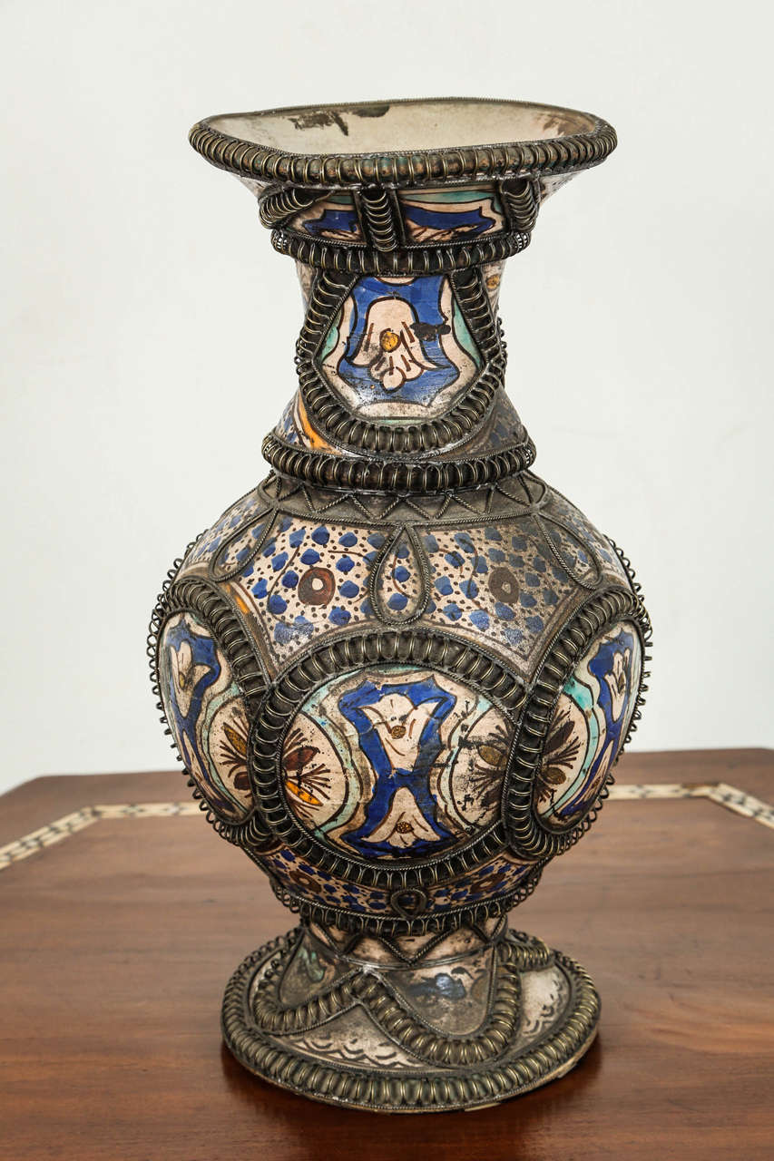 Antique Moroccan ceramic vase from Fez.
Moorish style handcrafted vase adorned with fine filigree silver nickel work.
Antique Moroccan ceramic bleu de Fez vase with some colors.