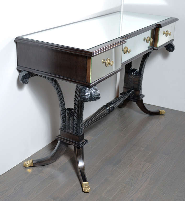 Hollywood mirrored vanity by Grosfeld House. Ebonized walnut, mirror  and brass fittings with stylized plume and balustrade detailing. This piece would also make an impressive writing desk and matching stool is also available. 
Completely restored