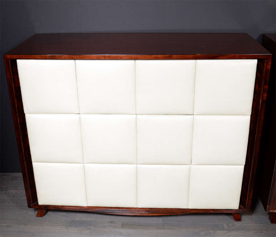 Pair of sensational Art Deco chests designed by Gilbert Rohde for Herman Miller. Made with fine book matched mahogany with tufted  creme leather facade. Three generous drawers per chest  provides abundant storage. This piece has been completely