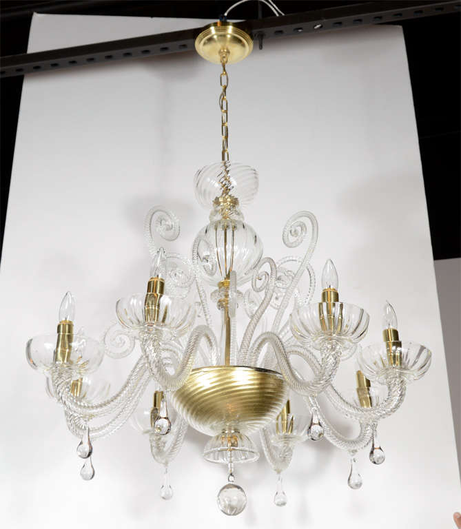 Superb quality 1920's Murano Glass eight arm chandelier with 24K gold flecks suspended in the glass. The chandelier features sixteen scroll arms and eight bulb lit arms with candle cups finished with drop crystals.Great classic design that will mix