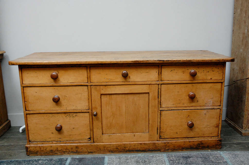 A sideboard or server with circular wood knob pulls and a plinth base