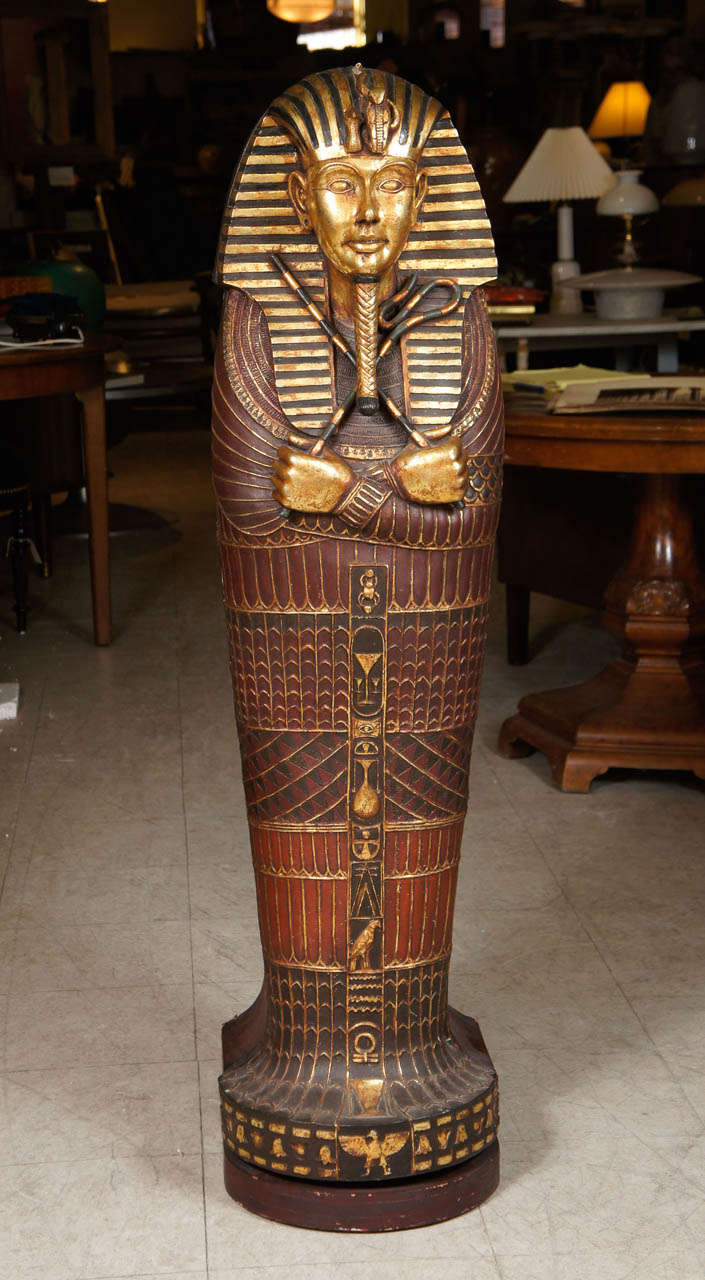 The case decorated overall to resemble Tutankhamun's mummy case. The front swings open to reveal shelving meant to store CDs.